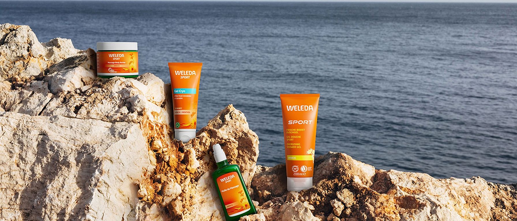 Weleda Arnika Produkte auf einem Felsen am Meer