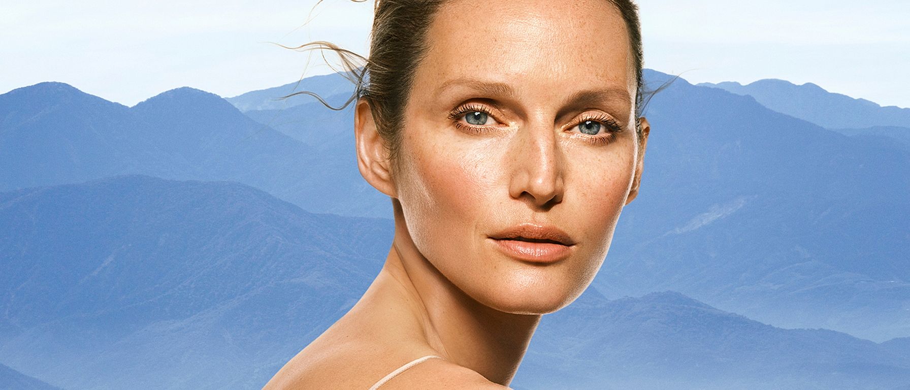 Portrait einer Frau mit blauen Bergen im Hintergrund