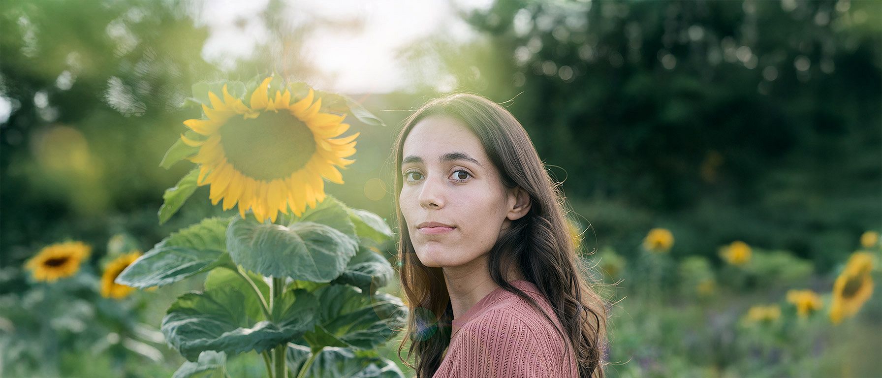 Frau in einem Sonnenblumenfeld an einem sonnigen Tag