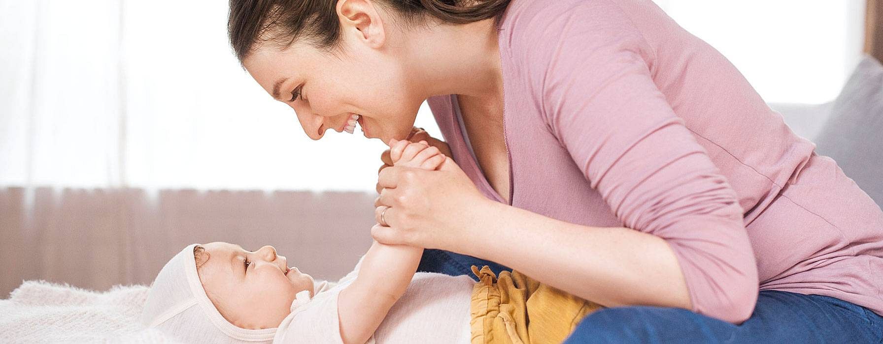 Frau lacht dem Baby zu