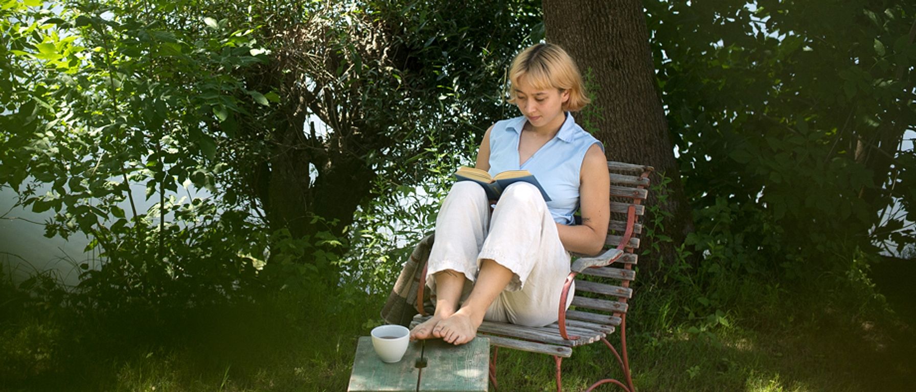 Frau sitzt entspannt im Garten