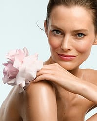 Woman holding rose by shoulder