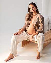 Pregnant woman applying oil on baby bump