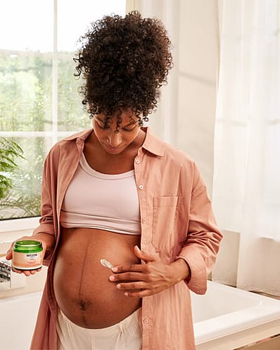 Gravid kvinna smörjer in magen