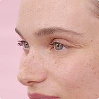 Young woman in front of a pink background.