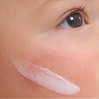 Gesichtscreme auf Babywange