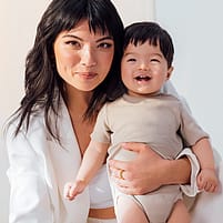 Woman holding smiling baby standing up