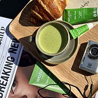 Table in Paris featuring Skin Food, a matcha, newspaper and baked good