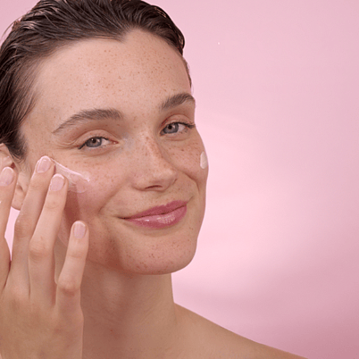 jeune femme qui s'applique de la crème