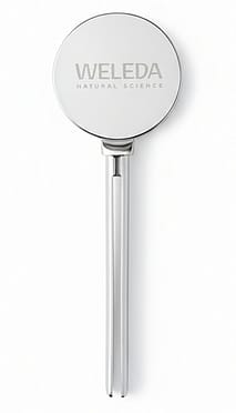 Metal tube squeezer key with Weleda Natural Science branding, tool for efficiently dispensing skincare or toothpaste from tubes.