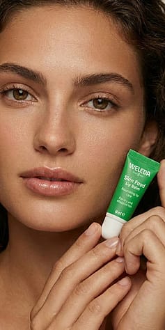 žena ukazuje skin food balzám na rty