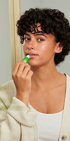 žena ukazuje skin food balzám na rty