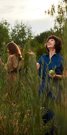 Woman eating an apple in a field.