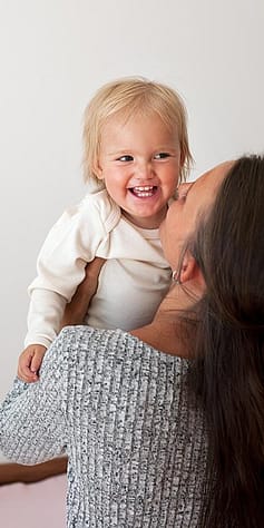 madre cogiendo a bebé sonriendo