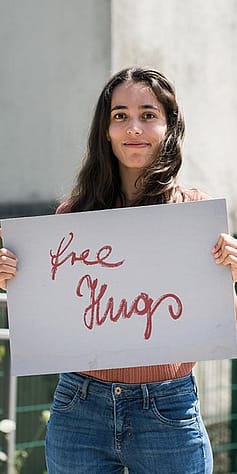 woman holding free hugs sign