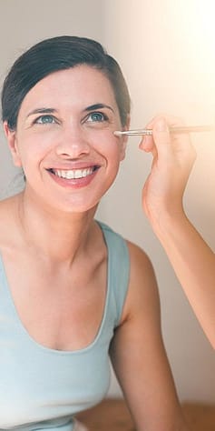 mujer maquillándose sonriendo