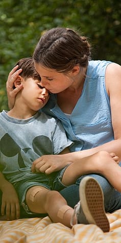 Woman holding child after injury.