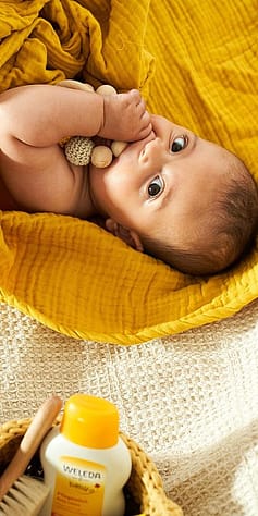 Baby in yellow wrap sucking his thumb