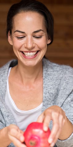 žena drží granátové jablko