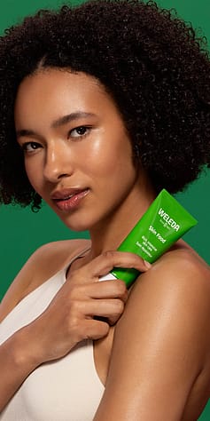 Žena drží v rukou Weleda Skin Food krém