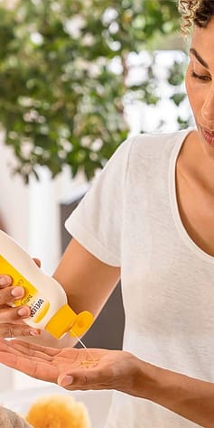 Mother putting calendula baby oil onto her hand