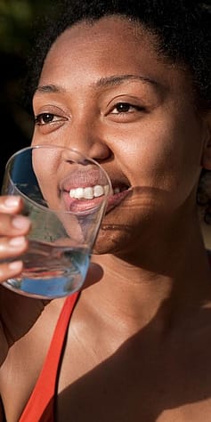 Frau trinkt aus Wasserglas