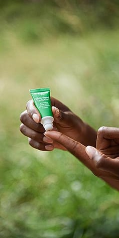 Hand holding Skin Food Lip Balm