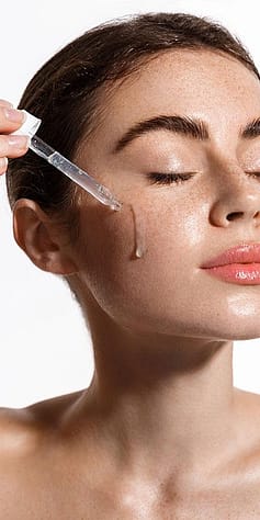 Frau traegt Serum im Gesicht auf