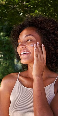 Kvinna smörjer in sig med Weleda Skin Food ansiktskräm