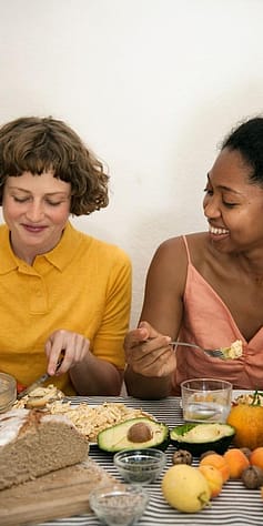 Zwei Frauen essen Früchte, Avocado, Vollkorn Brot, Haferflocken, Kerne, Nüsse
