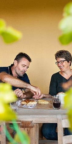 Två personen i suddig bild sitter brevid varandra vid ett bord