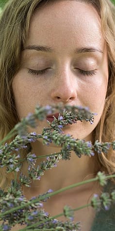 Ragazza annusa la lavanda con gli occhi chiusi