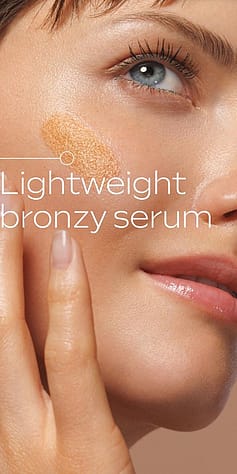 Tjej håller upp Weleda Sunkissed Bronzing Serum Drops mot ansikte