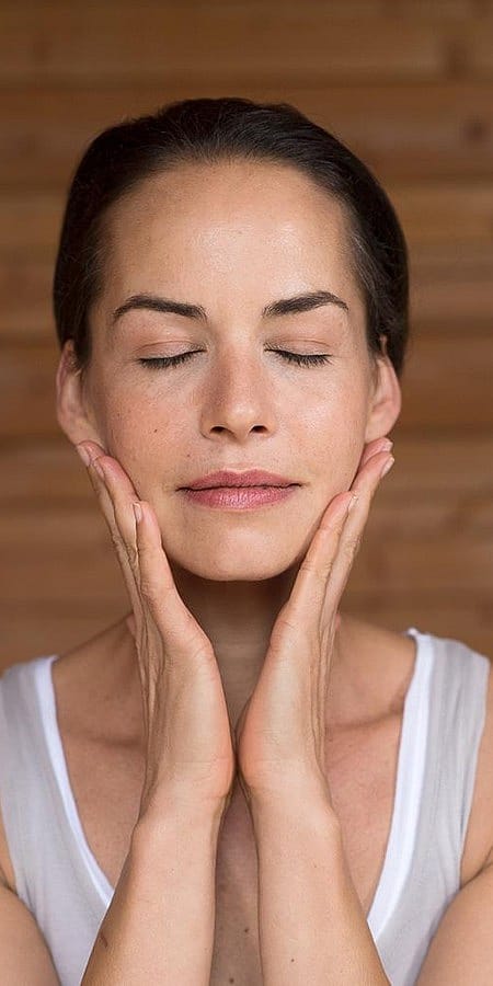 Kvinna smörjer in sig med Granatäpple Firming Facial Oil