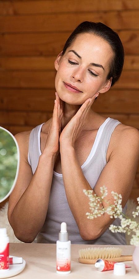 Kvinna smörjer in sig med Granatäpple Firming Facial Oil