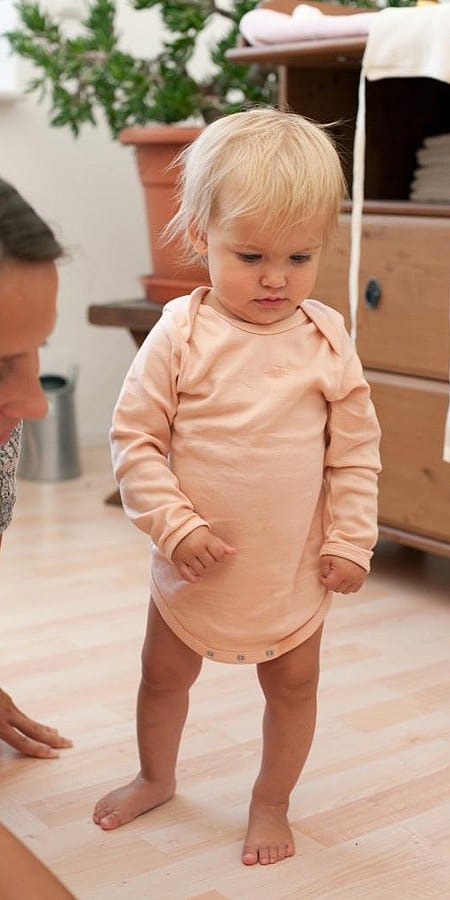 Bimbo scalzo in piedi vicino la mamma