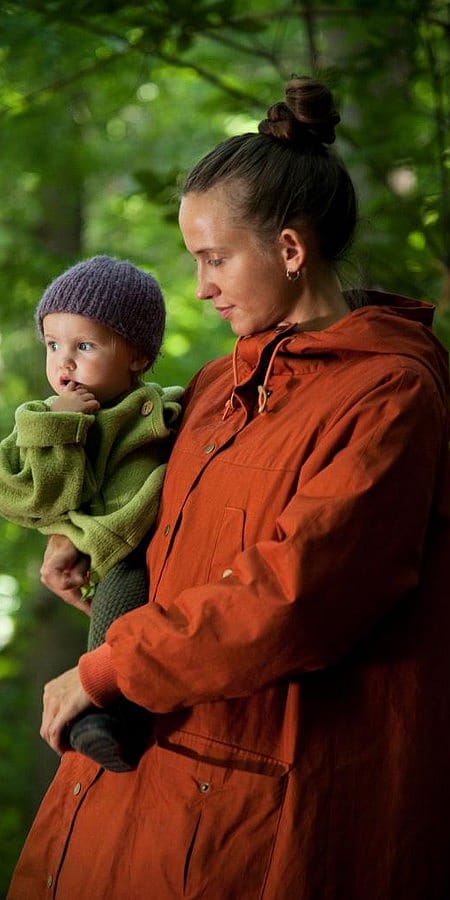 Donna tiene in braccio un bambino nel bosco