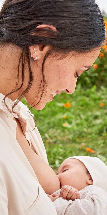 Mamma allatta neonato e sorride