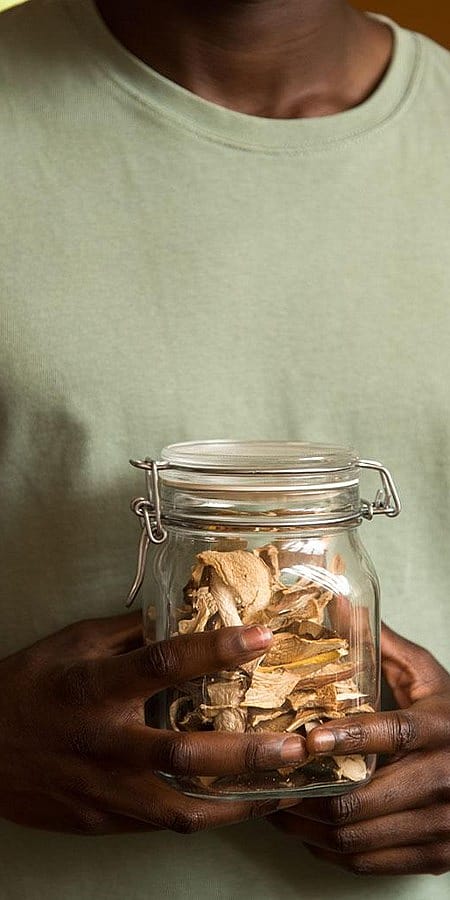 Mann hält Behälter mit Trockenfrüchte