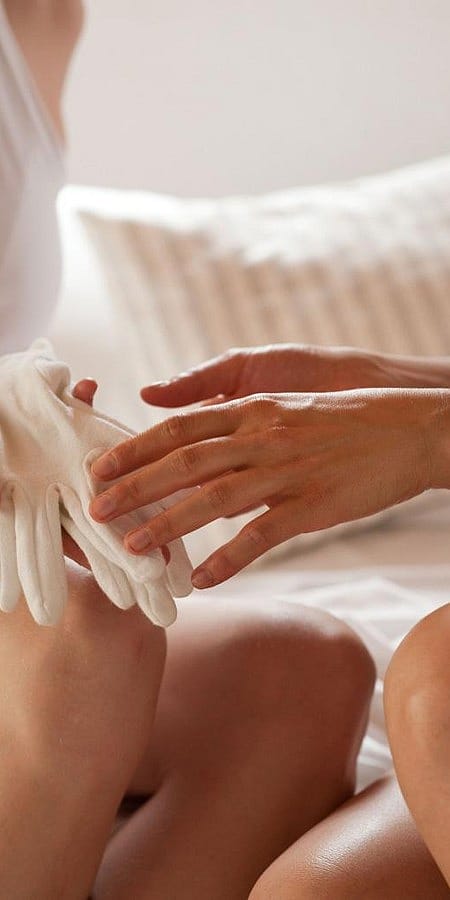 una ragazza inserisce i guanti ad un'altra ragazza per proteggere la nutrizione