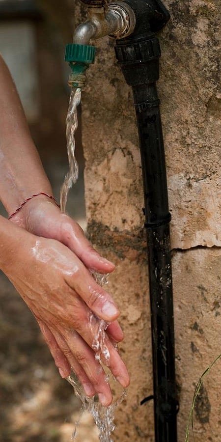 dettaglio di mani sciacquate sotto un getto d'acqua
