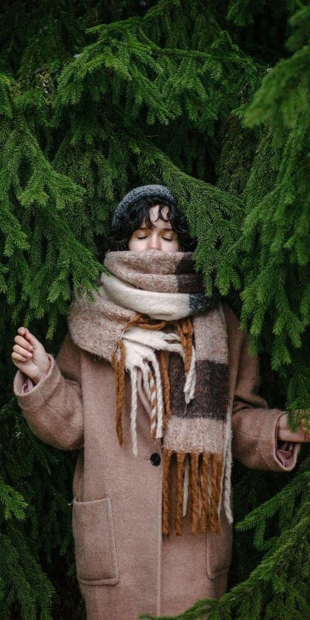 Frau inmitten von Tannen