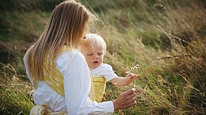 Woman carrying baby outside.