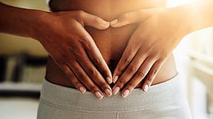 Frau legt ihre Haende auf den Bauch