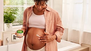 Pregnant woman applying Stretch mark cream to her belly