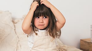 petite fille qui se gratte la tête