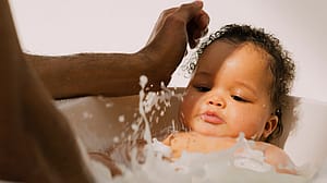 Dad washing baby in the bath