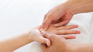 frau führt handmassage durch