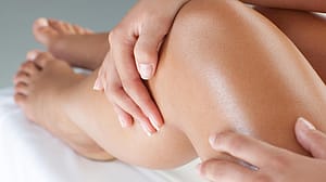 Une femme passe sa main sur ses jambes