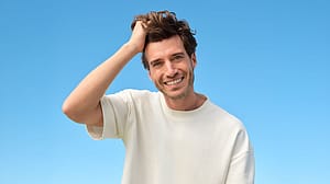 Mann greift sich ins Haar